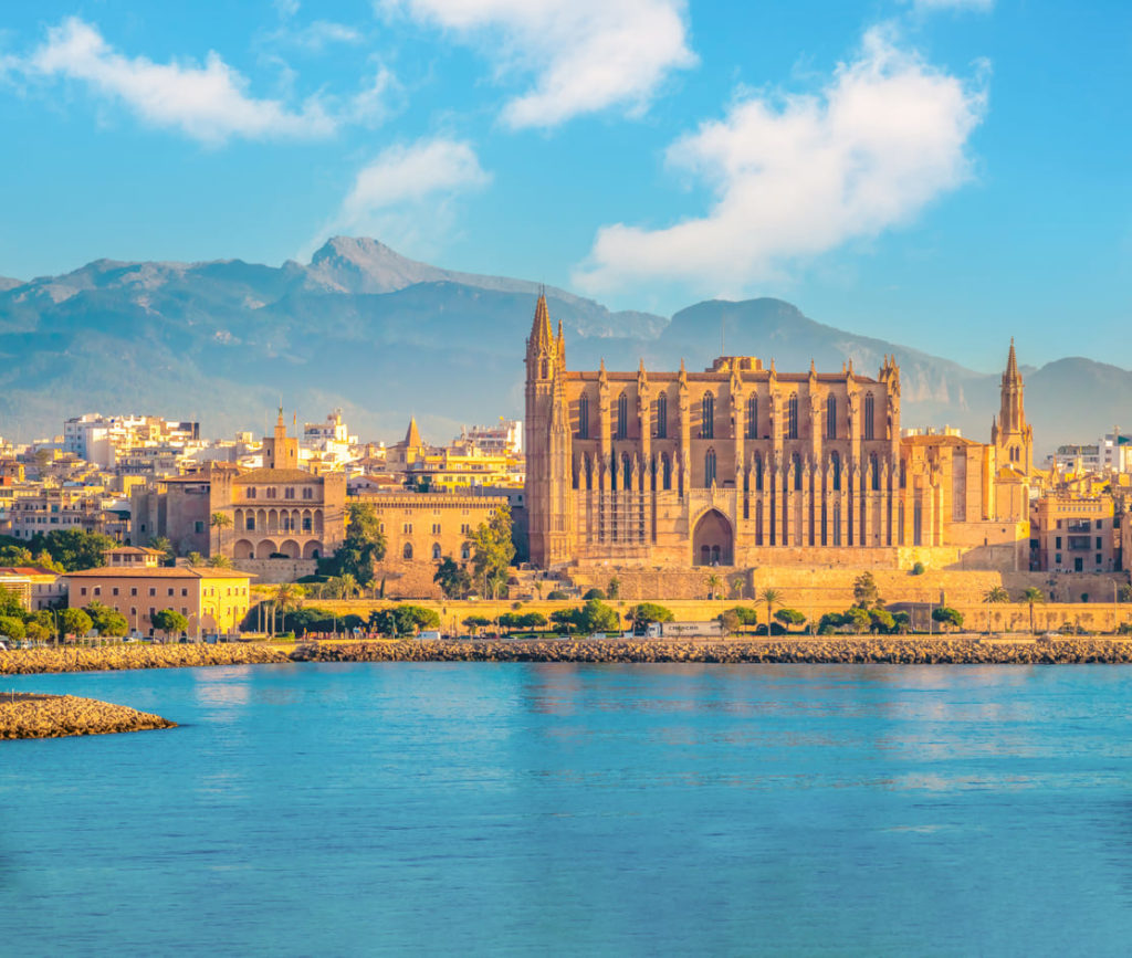 Die ikonische gotische Kathedrale (La Seu) und die Altstadt von Palma de Mallorca mit den Bergen im Landesinneren im Hintergrund.